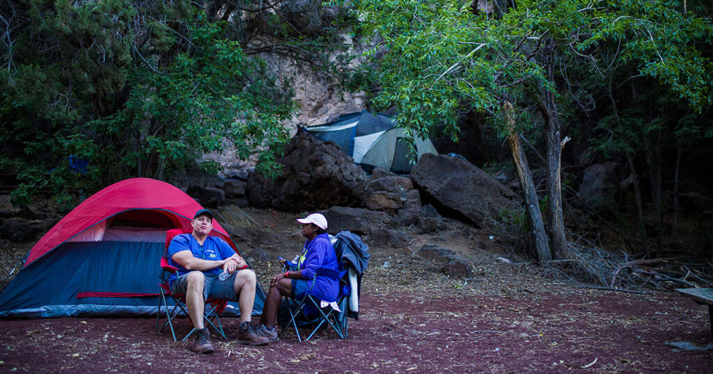 Campers relaxing near their tent at Veyo Pool.